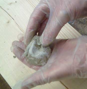 Epoxy putty being mixed in the gloved hand